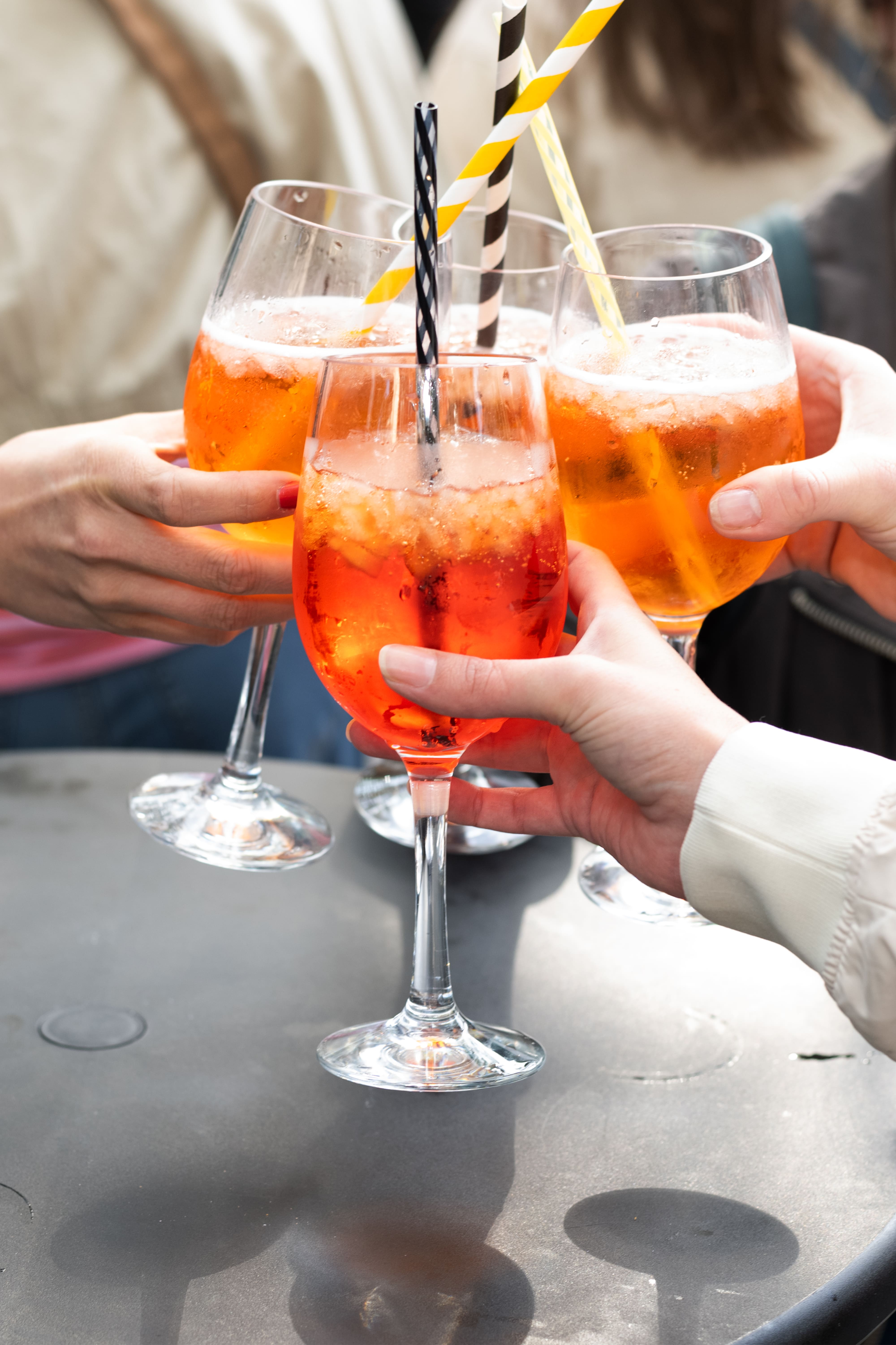 
Vier Aperol Spritz beim Anstoßen auf dem Feierabendmarkt am Chlodwigplatz in Köln
