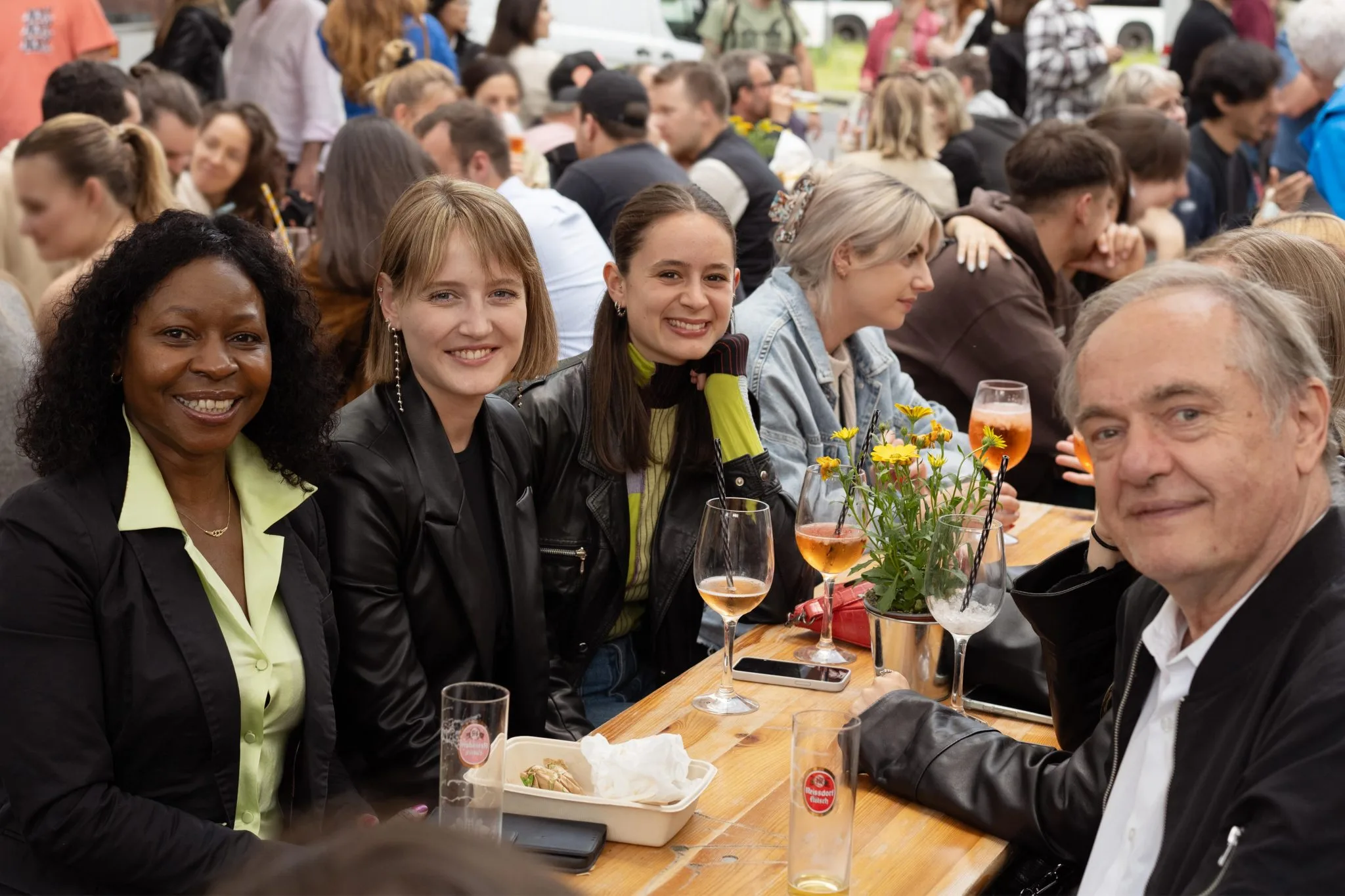 Gruppe von Freunden genießt den Feierabendmarkt am Chlodwigplatz in Köln mit Aperol und Streetfood