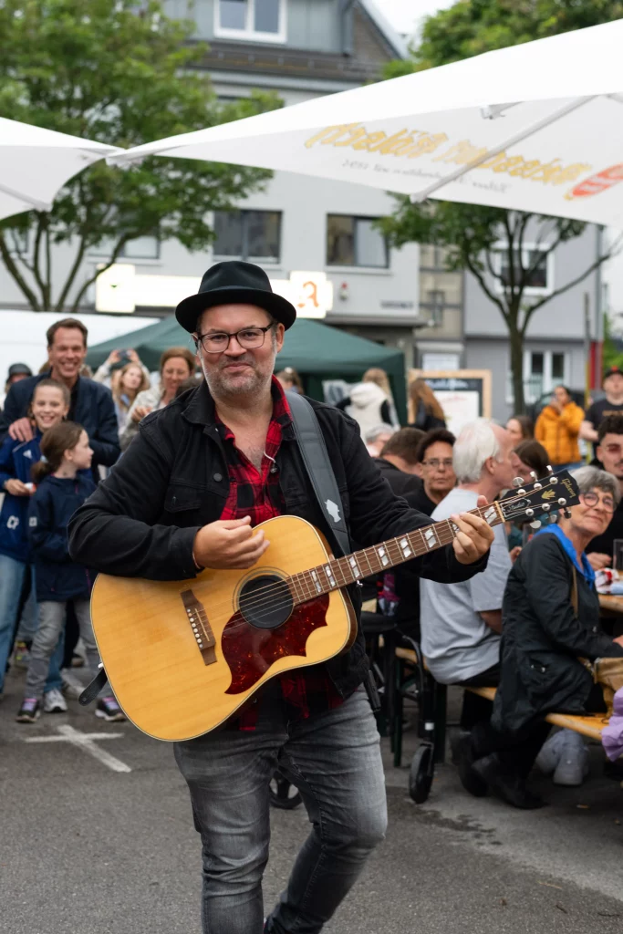 Björn Heuser spielt Gitarre und singt live auf dem Feierabendmarkt am Hermeskeilerplatz in Köln