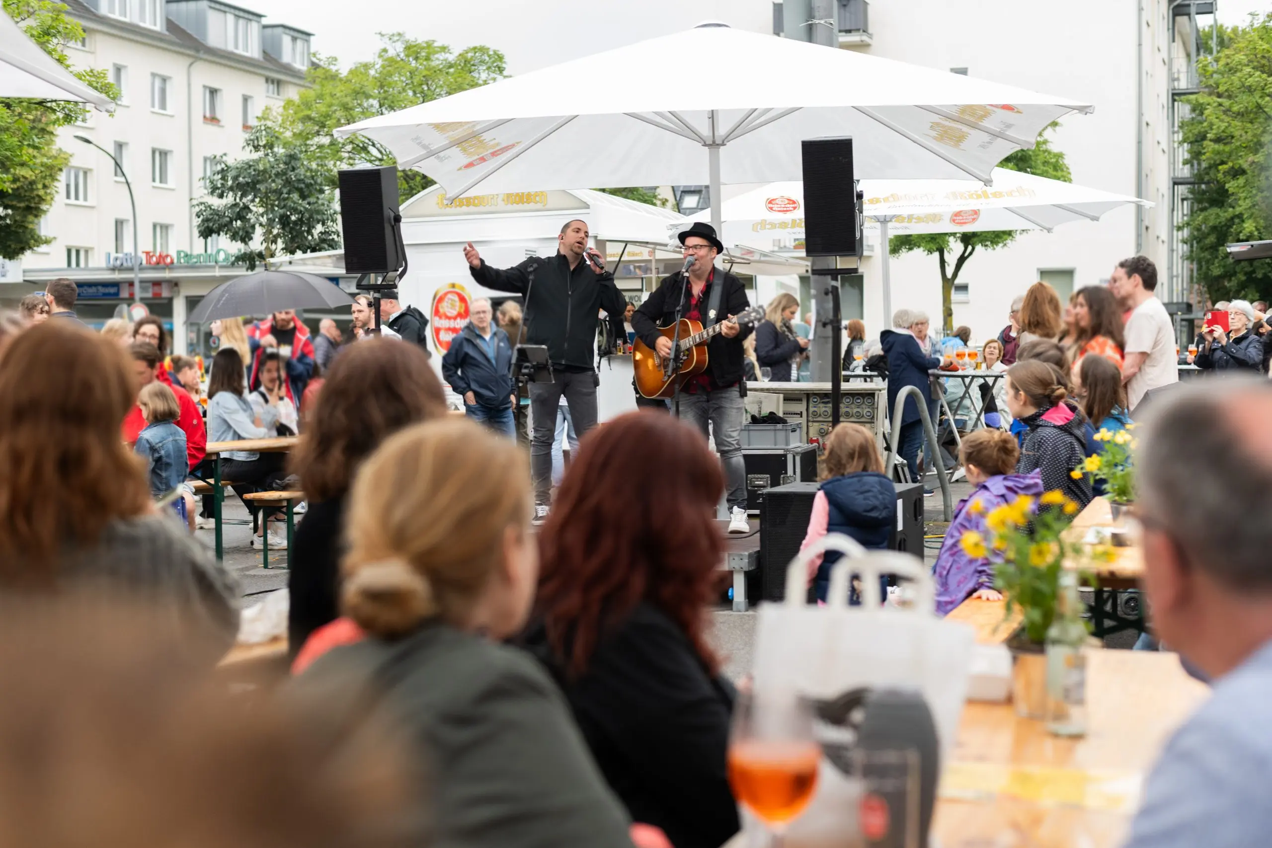 Björn Heuser und ein Sänger treten live auf dem Feierabendmarkt am Hermeskeilerplatz in Köln auf.