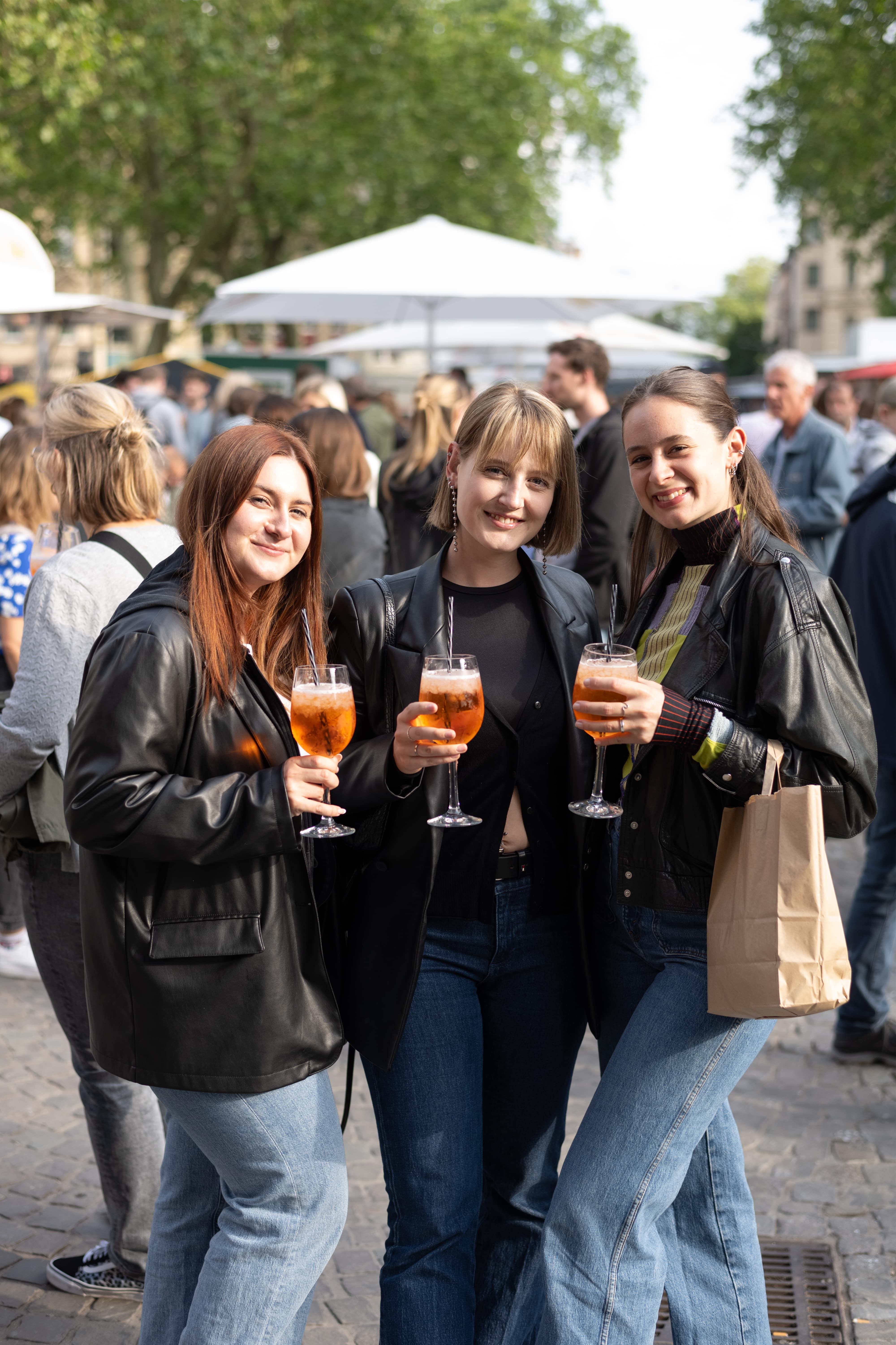 
Drei Freundinnen genießen Aperol Spritz auf dem Feierabendmarkt in Köln
