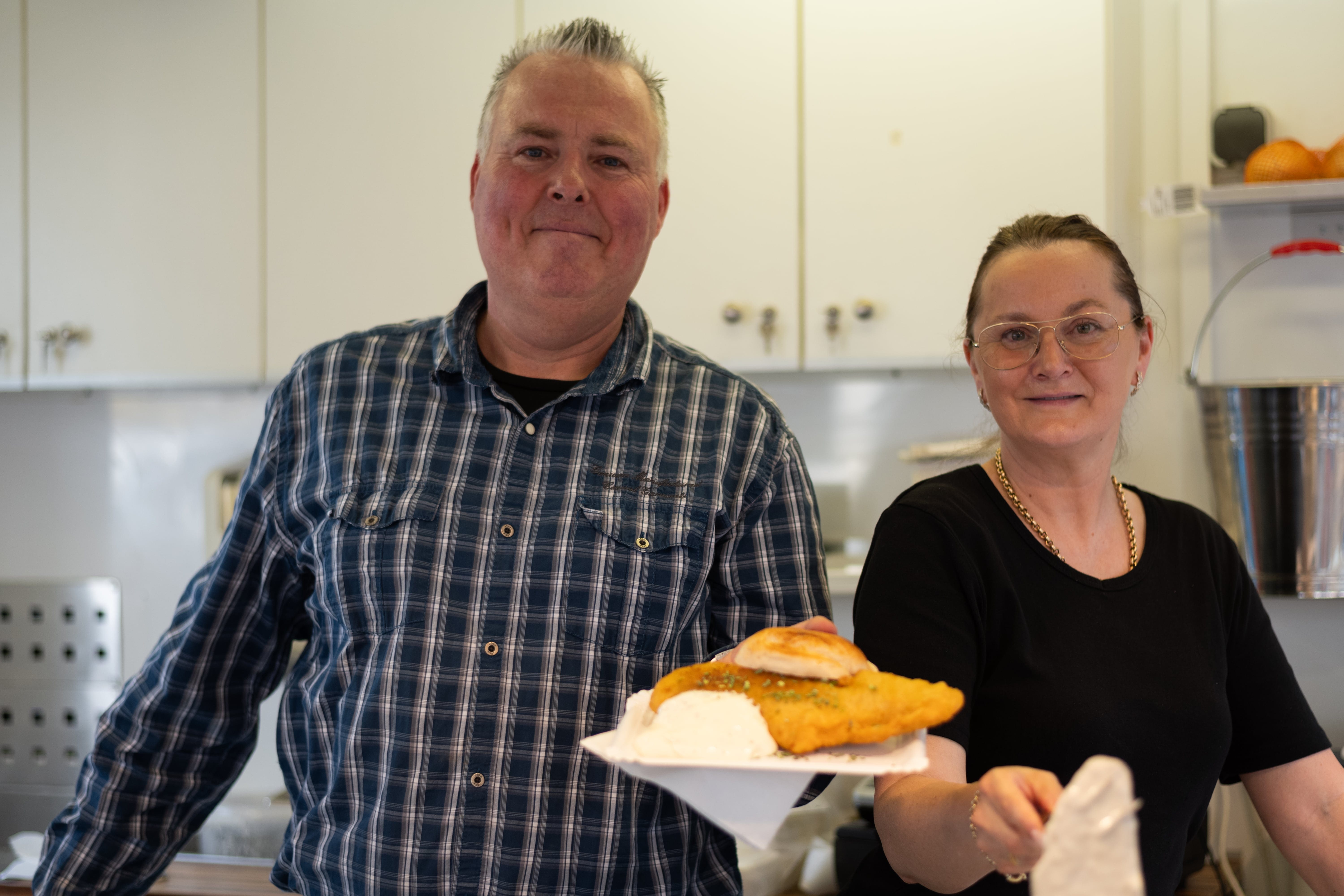 
Zwei Foodtruck-Betreiber servieren frisch zubereitetes Essen auf dem Feierabendmarkt
