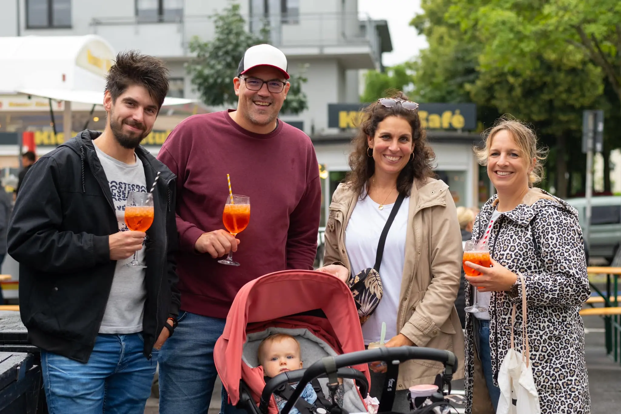 Familie mit Kinderwagen genießt Aperol und Streetfood auf dem Feierabendmarkt Köln