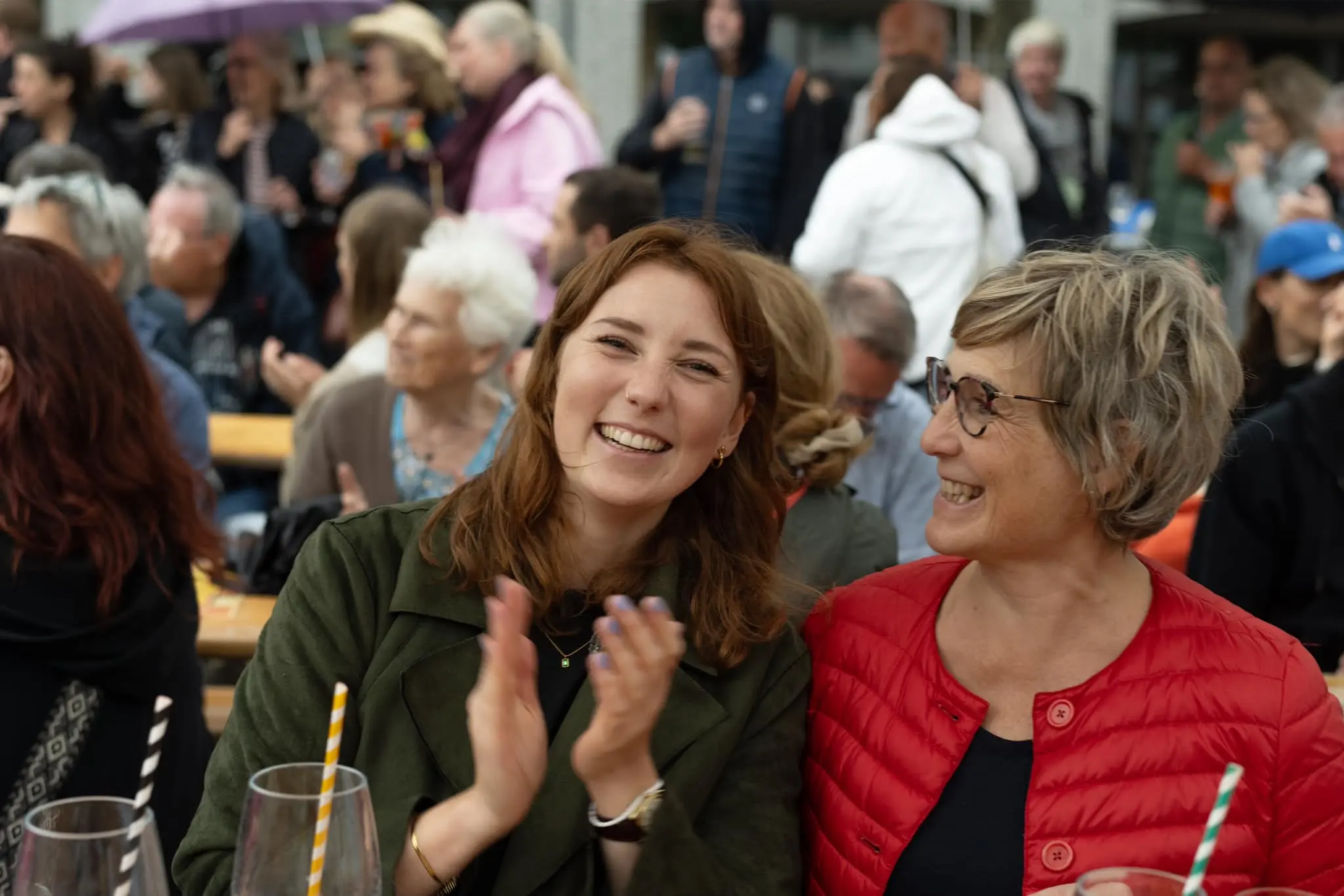 Zwei lachende Frauen klatschen begeistert während einer Live-Performance auf dem Feierabendmarkt am Hermeskeilerplatz