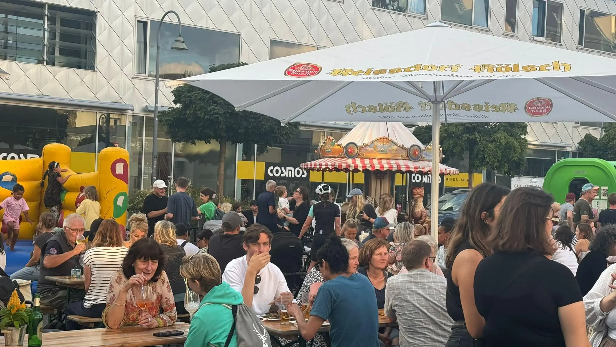 Familien und Kinder genießen den Feierabendmarkt am Neptunplatz in Köln mit Hüpfburg und Karussell
